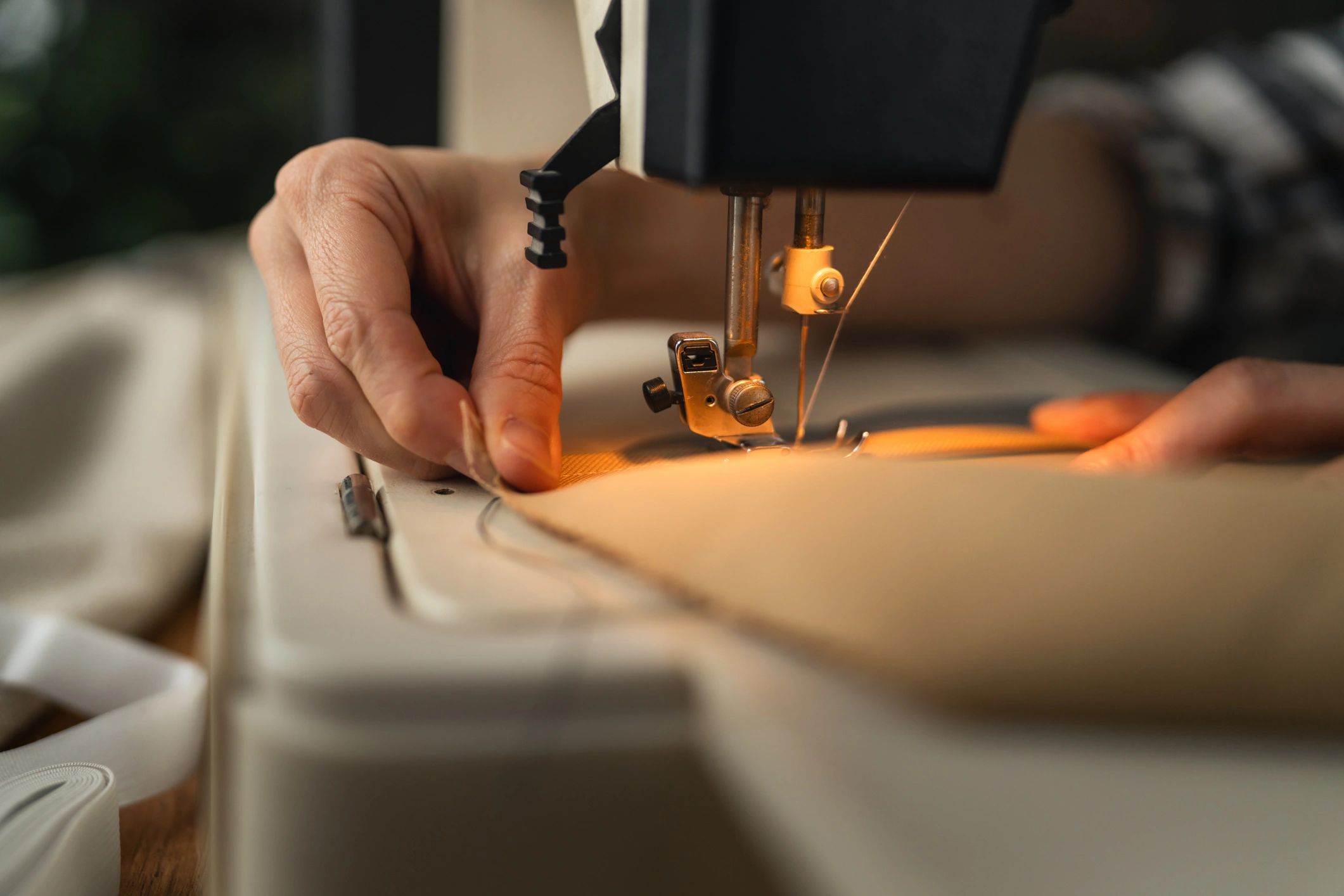 Hands sewing durable canvas fabric on a sewing machine